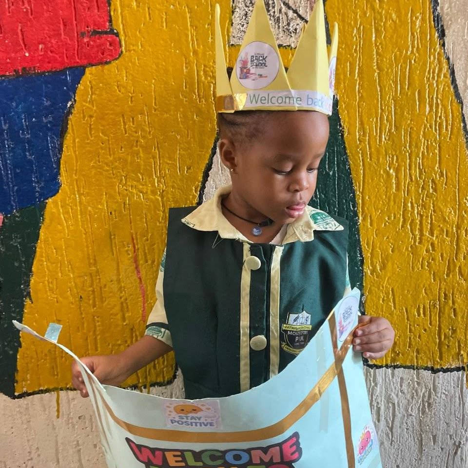 Young child with a paper crown at school